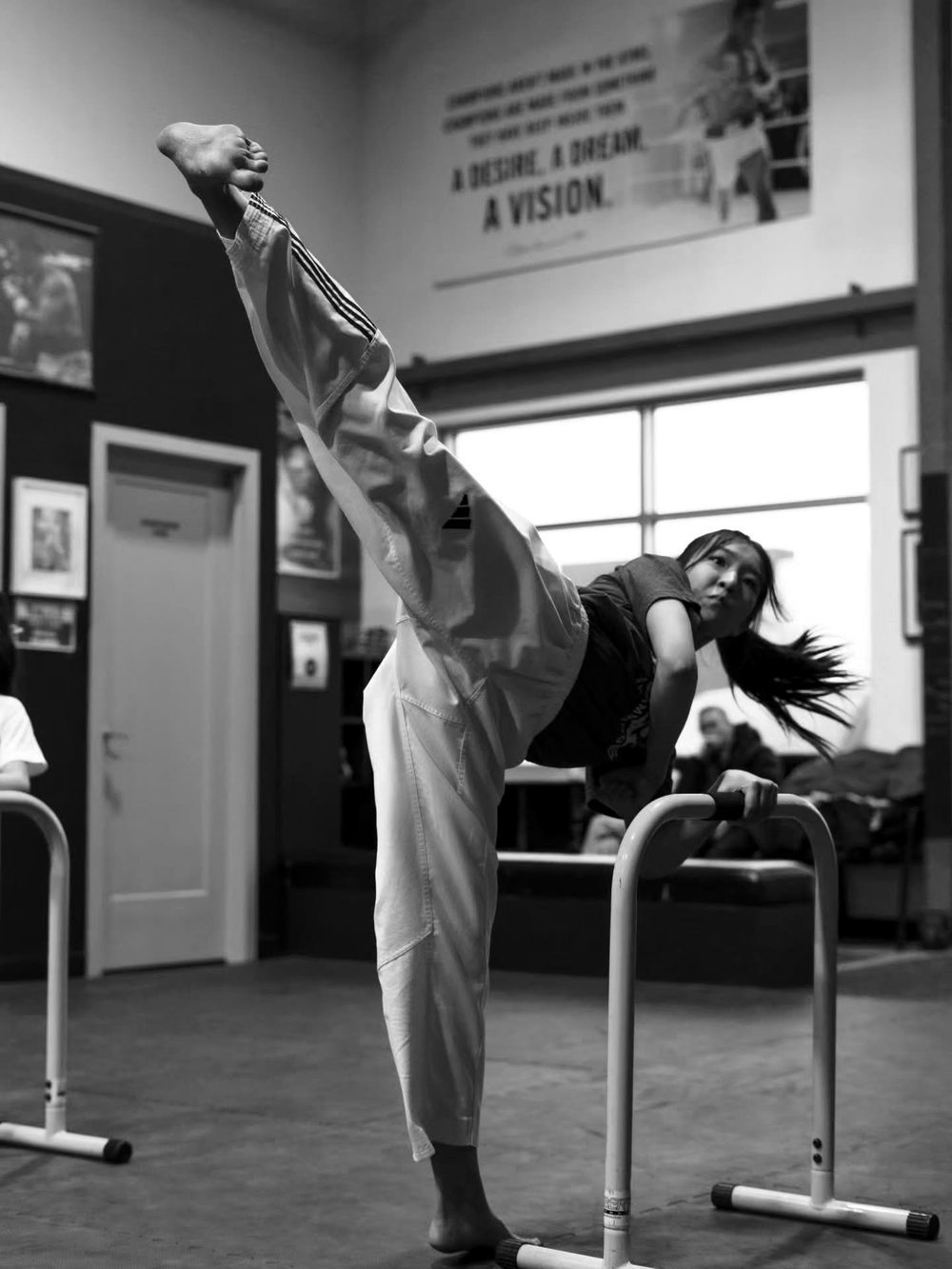 MYM Taekwondo teen athlete holding a high side kick during training